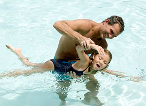 Adult teaching child to swim