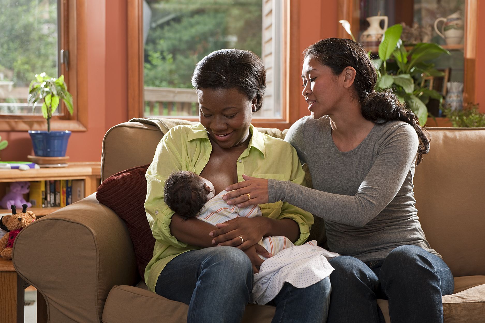 Breastfeeding counselor helping new mother breastfeed 